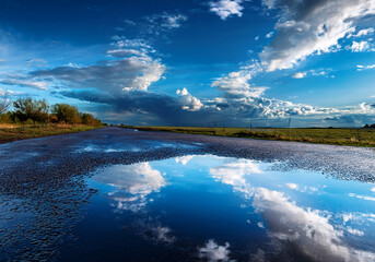 雨上がりの水たまりにうつる青空