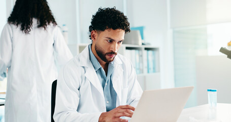 Serious, man and scientist on laptop in lab for research, reading study and medical experiment....
