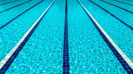 Obraz premium Bright, clear swimming pool with marked lanes under sunlight showcasing vibrant blue water
