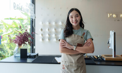 Young entrepreneur smiling with arms crossed, proud owner of a modern coffee shop