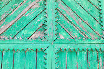 Textured green wooden door with intricate patterns and weathered finish, architectural detail