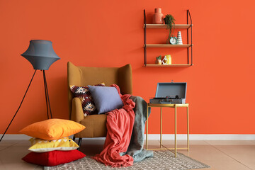 Interior of living room with armchair, pillows and record player