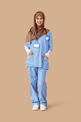 Female Muslim medical intern on beige background