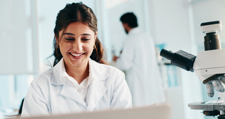 Fototapeta premium Woman, scientist and smile at laboratory, laptop or medical research with project for vaccine. Person, happy and computer for pharmaceutical study with feedback, problem solving or solution for virus