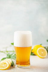 Boozy Refresing Cold Lemon Beer or Radler in a Pint Glass  on the table.