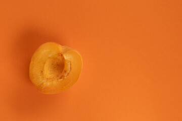 halved apricot on orange background