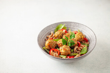 Vegan food. Vegetable meatballs and buckwheat pasta with vegetables in a bowl on the table.