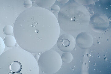 A macro abstract image of oil bubbles layered across a sponge-like surface. The organic shapes and soft gradients evoke themes of skincare, hydration, and minimalist beauty.
