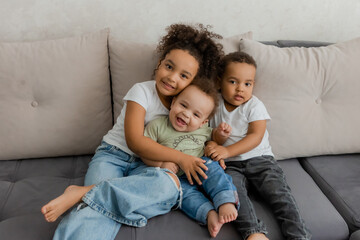 Fototapeta premium three African-American children hugging at home