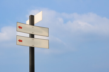 Signboard with sky background and direction arrows