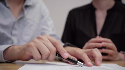 Business experts analyzing contract terms, signing legal paperwork with concentrated teamwork, hands visible during professional partnership meeting at wooden workspace - Powered by Adobe