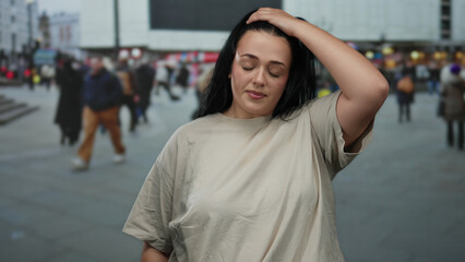 Woman standing on a busy city street with a crowd in the background, showcasing urban outdoor...