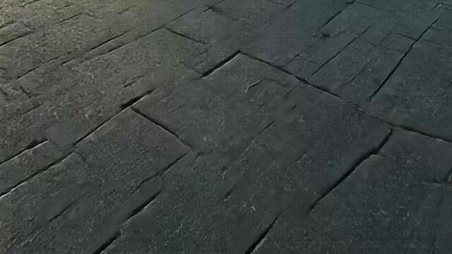 Dark gray stone pavement in herringbone pattern