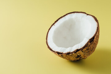 Fresh Coconut Half on Yellow Background with Smooth Shell and White Edible Flesh