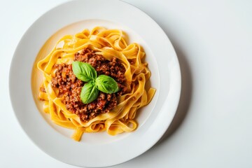 Tagliatelle pasta with Bolognese sauce, neatly swirled on a round white ceramic plate, garnished with fresh basil on top.