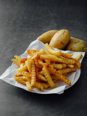Crispy Golden Crinkle Cut French Fries with Fresh Potatoes on Plate