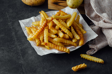 Crispy Golden French Fries on White Paper Plate with Rustic Background