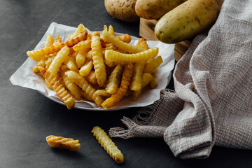 Crispy Golden French Fries on Plate with Potatoes and Linen Cloth