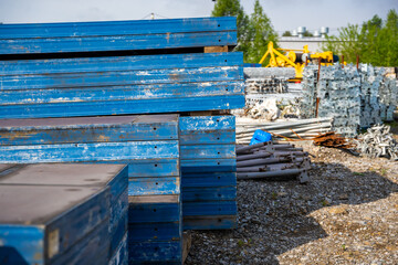 Stacks of blue metal formwork panels stored outdoors at a construction site. Concept of reusable...