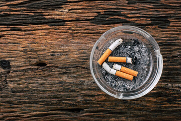 Ashtray Containing Cigarette Butts on Rustic Wooden Surface