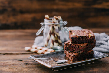 Delicious Chocolate Brownies on Plate with Sweets in Background