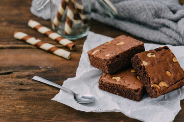 Delicious Brownie Dessert with Nuts and Chocolate on Wooden Table