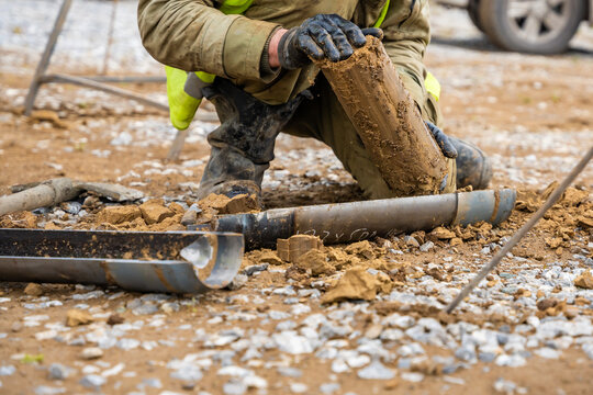 Man cutting and cleaning soil sample for laboratory analysis. Preparation of core material for geotechnical testing and scientific evaluatio