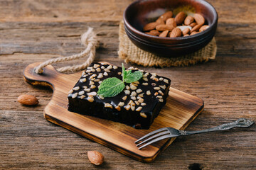 Delicious Chocolate Brownie with Nuts on Wooden Board and Fork