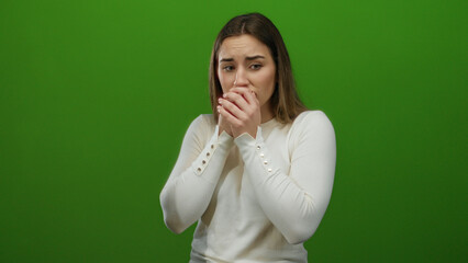 Woman surprised on green background depicting shock and emotion with a blank wall highlighting the...