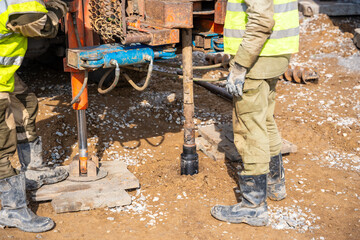 Close-up of soil sampling during pile drilling process. Extraction of subsurface material for...