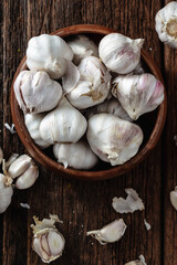 Fresh Garlic Bulbs in a Rustic Wooden Bowl on a Wooden Surface