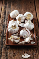 Fresh Garlic Bulbs and Cloves on Wooden Tray Background