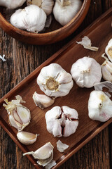 Fresh Garlic Bulbs and Cloves on Wooden Surface with Bowl