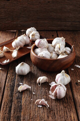 Fresh Garlic Bulbs in Wooden Bowl on Rustic Wooden Surface