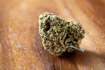 Close-up of Emerald Green Cannabis Bud on Natural Wooden Surface