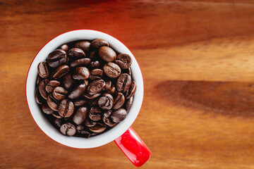 Fresh Coffee Beans in Red Cup on Wooden Surface Close-Up