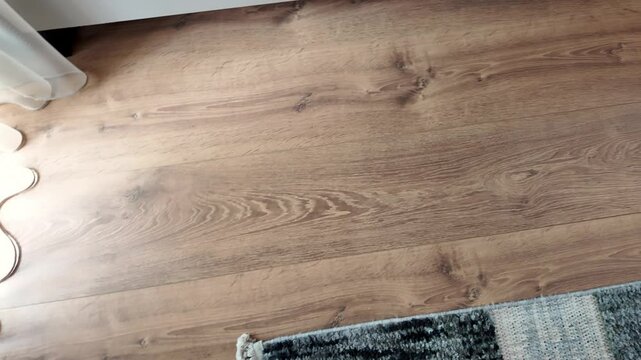 Natural wood laminate parquet floor. Room with floating laminate in new apartmen. Cozy home interior, modern design