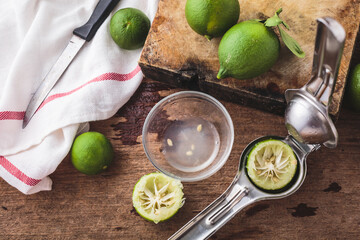 Fresh Limes and Juicer on Rustic Wooden Table with Knife