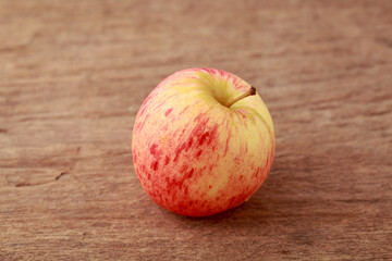 Fresh Red Apple on Rustic Wooden Surface with Natural Lighting