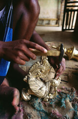 indian artisan working on brass lamp India