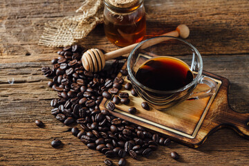 Freshly Brewed Coffee with Honey and Coffee Beans on Wooden Table