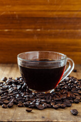 Freshly Brewed Coffee in Glass Cup Surrounded by Coffee Beans