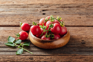 Fresh Red Tomatoes in a Wooden Bowl on Rustic Wooden Surface