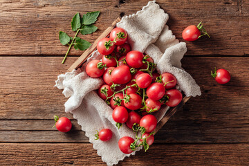 Fresh Cherry Tomatoes on Wooden Table with Soft Cloth and Green Leaf