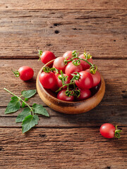 Fresh Cherry Tomatoes Gathered in a Rustic Wooden Bowl on Table
