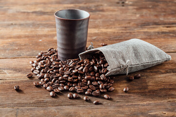 Rustic Coffee Scene with Beans, Mug, and Fabric Bag on Wooden Table