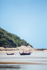 Fototapeta premium Fishing boats on serene beach under clear blue sky landscape