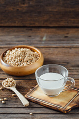 Fresh Soy Milk in Glass Cup with Soybeans on Rustic Wooden Table