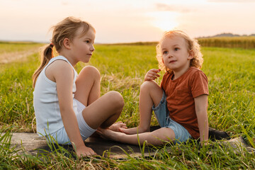 Little children practicing yoga poses in nature. Healthy family image.