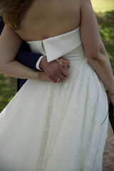 Back view of a bride holding hands with the groom